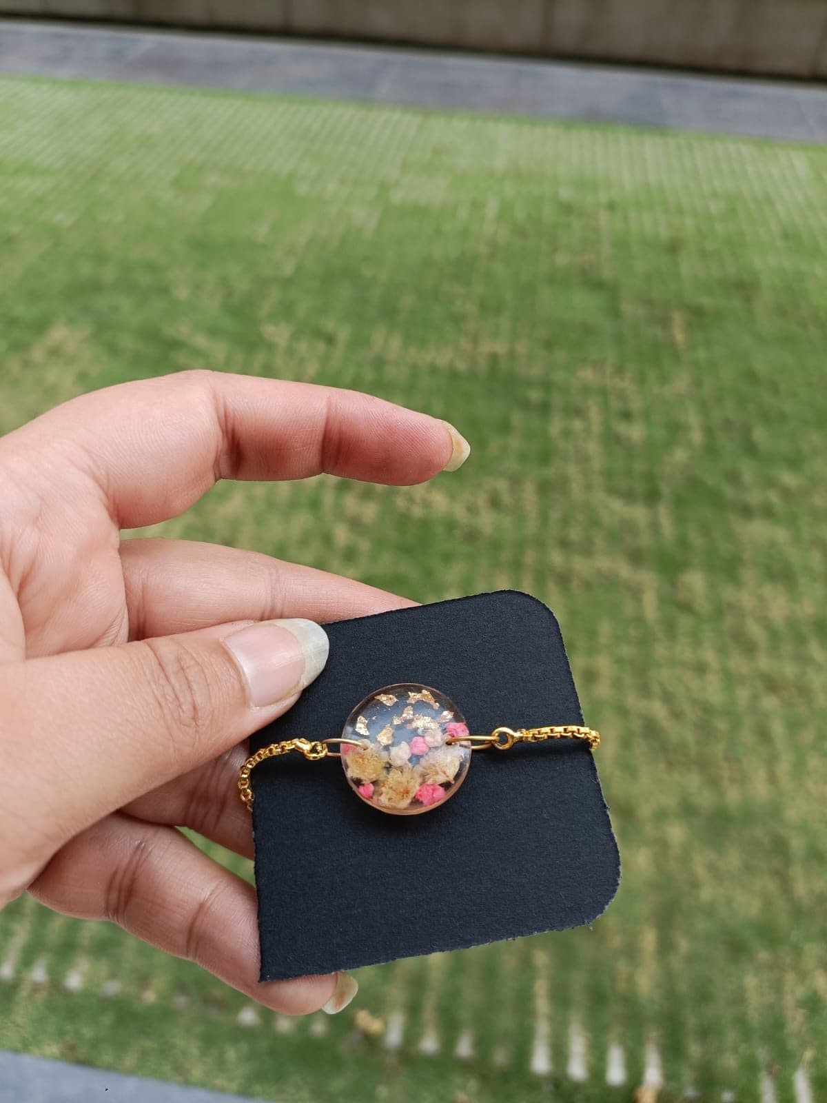 Adjustable bracelet with a round floral resin charm