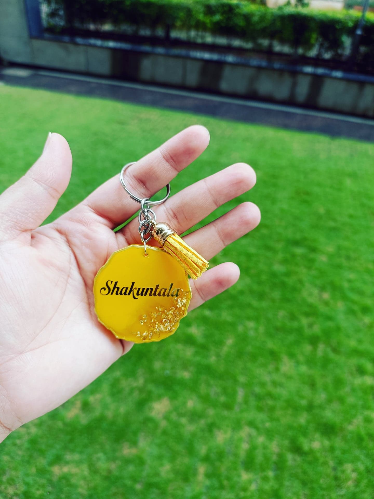 Yellow resin keychain with the name Shakuntala