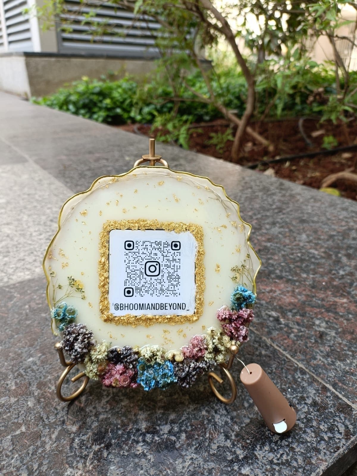 Floral resin plaque with a QR code for Bhoomi And Beyond on a stand